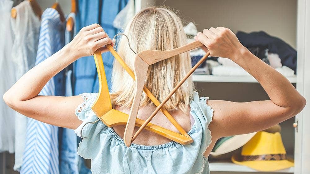 Woman looking at an open wardrobe - are you stuck in a style rut?